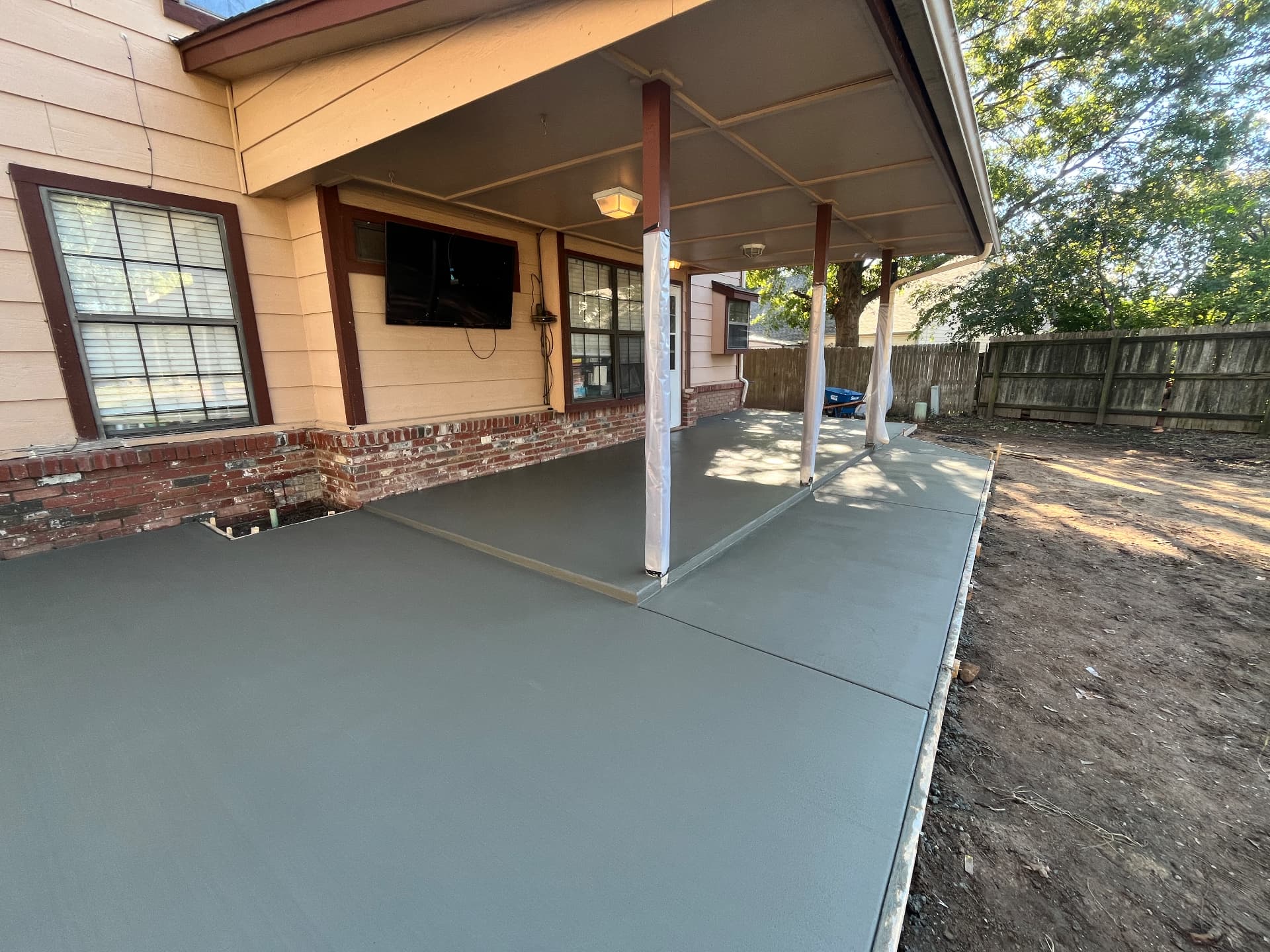 New broom-finish concrete patio under a covered back porch in Tulsa, OK